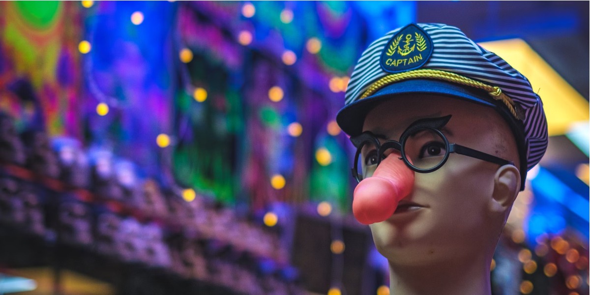 immagine banner con la faccia di un manichino e al posto del naso un dildo ,con sfondo sfuocato