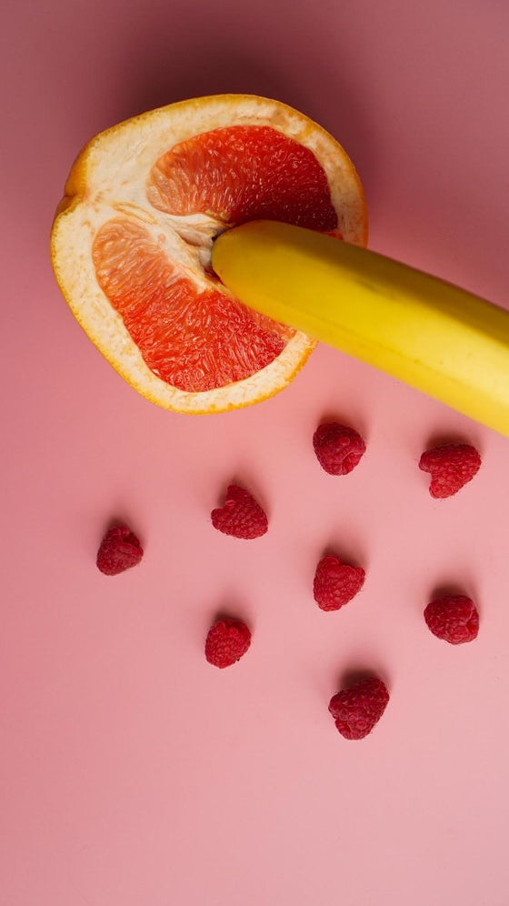 Aphrodisia.it-banana-with-red-grapefruit-raspberries-pink-background-sex-concept